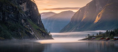 Ultrawide panorama of a Norwegian fjord at sunset, steep cliffs, still water, cinematic, generated at 21:9
